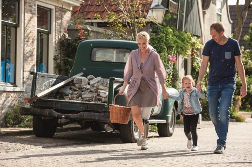 Foto van stel met kind wandelend door de straat